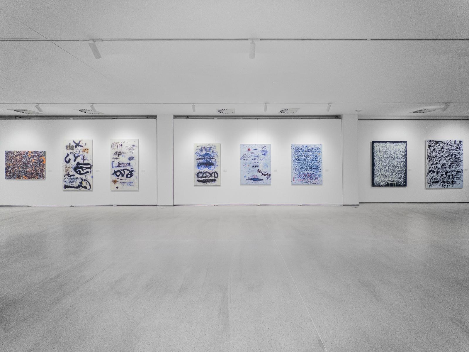 A long wall of Anima Mundi paintings inside Galerie Mánes
